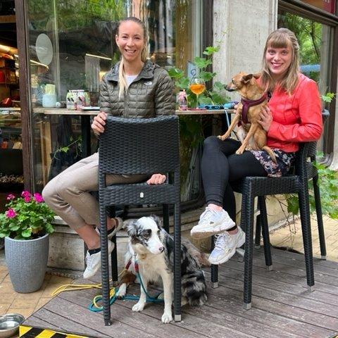 két nő kutyákkal egy kávézó teraszán