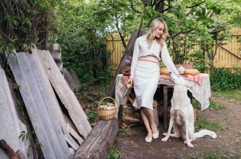 fehér ruhás nő fehér kutyával kertben